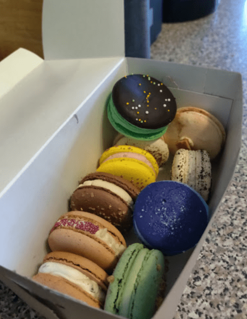 A box of colorful macarons in various flavors, including chocolate, vanilla, and vibrant pastel colors.
