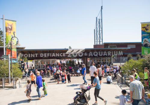 Crowd of visitors at the entrance of Point Defiance Zoo & Aquarium on a sunny day.