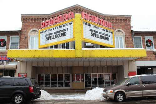 Historic theater marquee displaying "Alfred Hitchcock's Spellbound" with snow and holiday decorations outside.