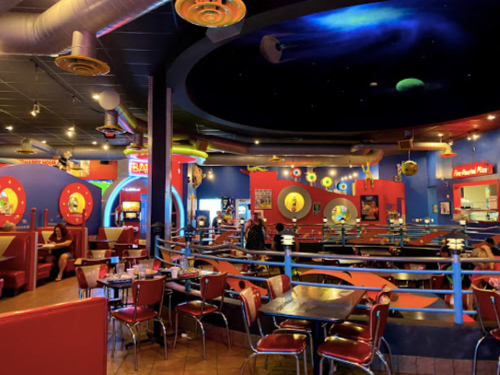 Colorful diner interior with retro decor, booths, and arcade games, creating a vibrant, playful atmosphere.