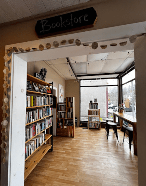 A cozy bookstore entrance with wooden shelves filled with books and a bright, inviting interior.