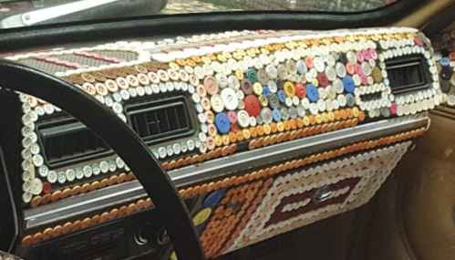 Colorful buttons cover the dashboard of a car, creating a unique and artistic interior design.