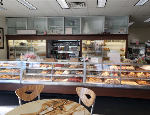 A bakery display case filled with various pastries and desserts, with a cozy seating area in front.