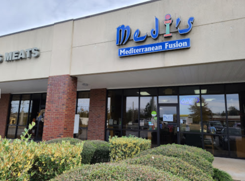 Exterior of Medi's Mediterranean Fusion restaurant, featuring a blue sign and a welcoming entrance.