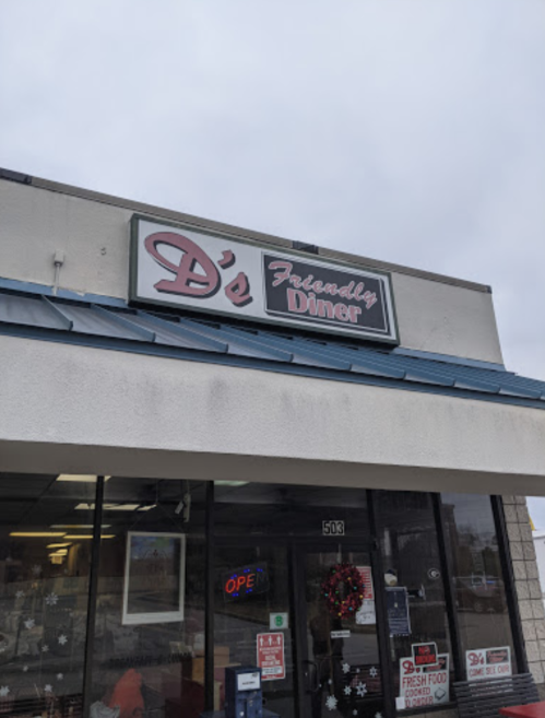 Sign for D's Friendly Diner, featuring a blue roof and large windows, with a wreath on the door.