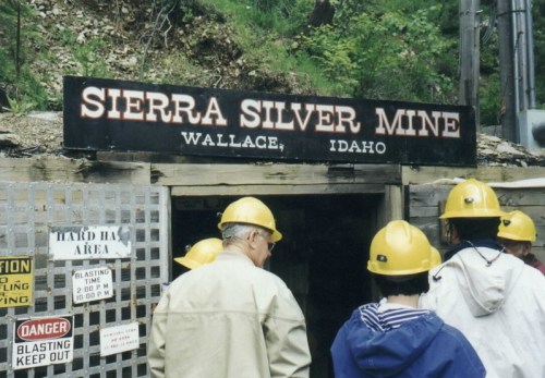 Visitors wearing hard hats stand in front of the entrance to the Sierra Silver Mine in Wallace, Idaho.