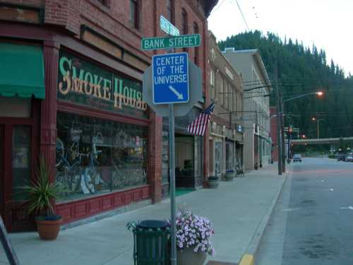 Street view featuring a sign for Bank Street and a "Center of the Universe" directional sign near storefronts.