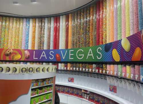 Colorful candy wall with various sweets and a sign reading "LAS VEGAS" in a vibrant candy store.