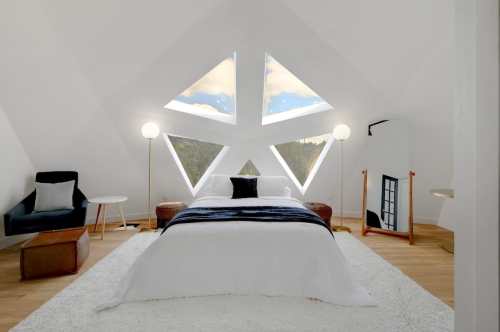 Bright, modern bedroom with unique triangular windows, a cozy bed, and stylish furniture in a minimalist design.