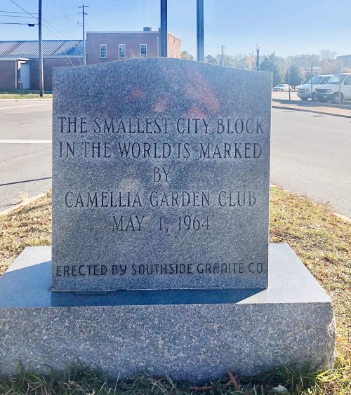 A granite marker commemorating the smallest city block in the world, established by the Camellia Garden Club in 1964.
