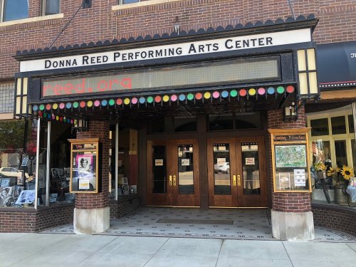 Entrance of the Donna Reed Performing Arts Center, featuring a marquee and colorful decorations.