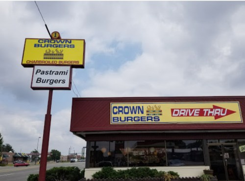 Signage for Crown Burgers featuring "Charbroiled Burgers" and "Pastrami Burgers," with a drive-thru option.
