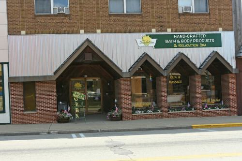 Exterior of a spa and bath products store with a welcoming entrance and flower planters.