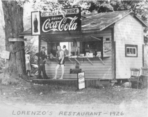 A vintage black-and-white photo of Lorenzo's Restaurant in 1926, featuring a small building and a Coca-Cola sign.