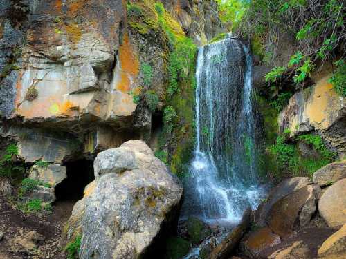 A serene waterfall cascades over rocky cliffs, surrounded by lush greenery and moss-covered stones.