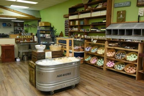 A cozy shop interior featuring shelves of colorful products, a wash station, and wooden displays.