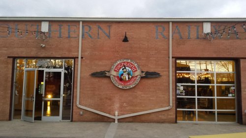 Exterior of a brick building with "Southern Railway" signage, featuring a round logo and large glass doors.