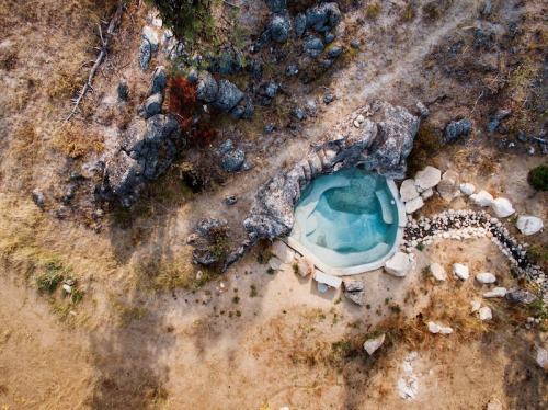 Aerial view of a natural hot spring surrounded by rocks and dry terrain.