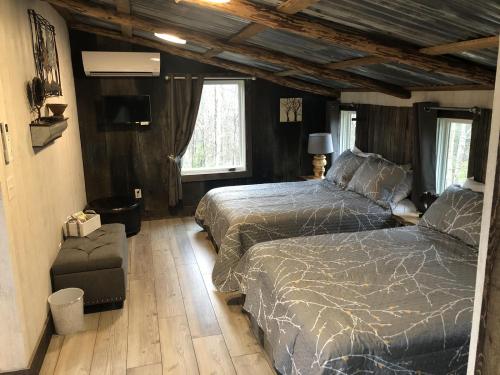 Cozy room with two beds, a TV, and a window, featuring rustic decor and wooden beams.