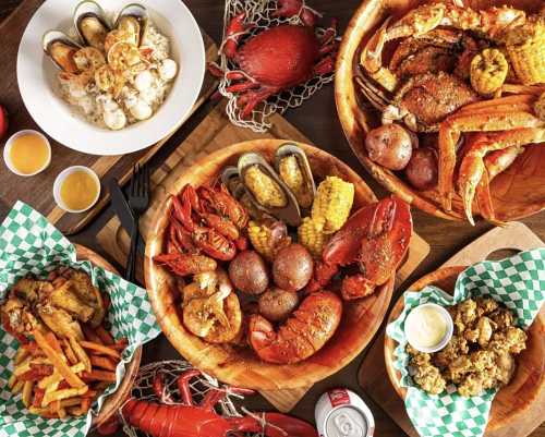 A spread of seafood dishes including crabs, lobsters, shrimp, corn, and fries, served in wooden bowls and baskets.