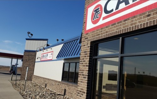 Exterior view of a building with a sign reading "Carquest" and a clear blue sky in the background.