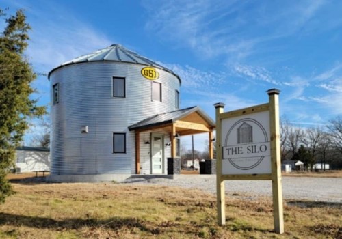 A modern, converted silo building with a sign reading "The Silo," set against a clear blue sky.