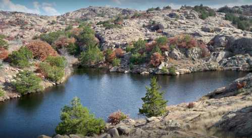 A serene landscape featuring a calm lake surrounded by rocky terrain and autumn-colored trees.