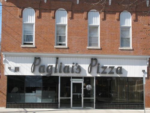 A brick building with large windows and a sign reading "Pagliai's Pizza" in a stylized font.