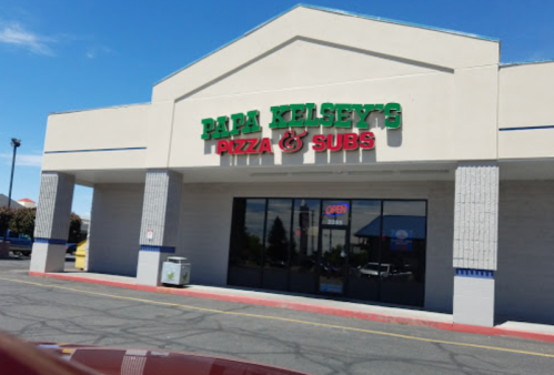 Exterior of Papa Kelsey's Pizza & Subs, featuring a bright sign and large windows, with an "Open" sign visible.