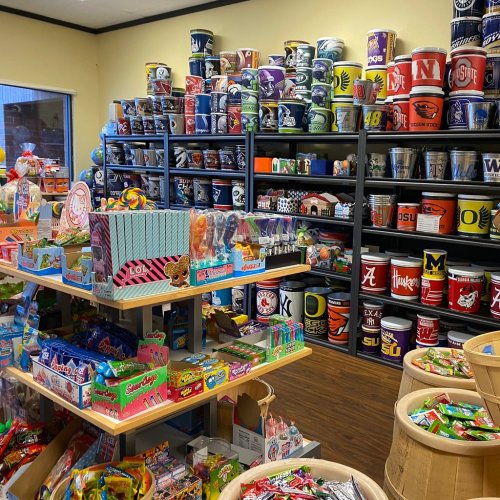 A colorful store interior filled with shelves of candy and various themed containers, creating a vibrant shopping atmosphere.