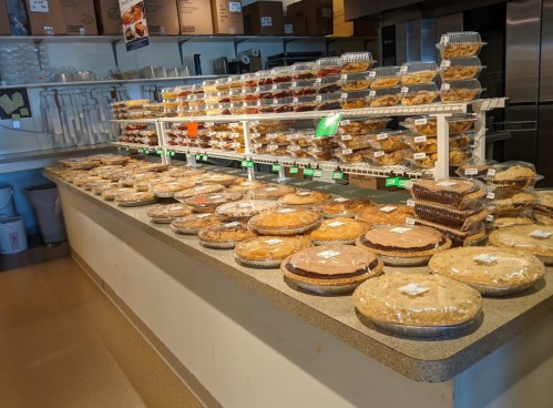 A display of various baked goods, including pies and pastries, arranged neatly on a countertop in a bakery.