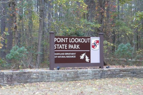 Sign for Point Lookout State Park, featuring the Maryland Department of Natural Resources logo, surrounded by trees.