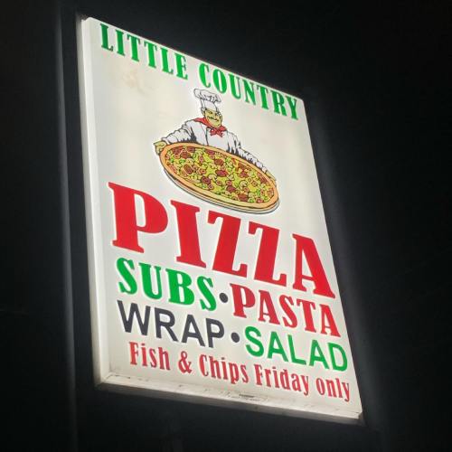 Sign for Little Country featuring menu items: pizza, subs, pasta, salad, wraps, and fish & chips available Friday only.
