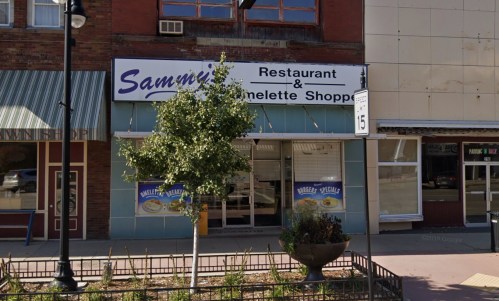 Exterior of Sammi's Restaurant & Omelette Shoppe, featuring a sign and a small tree in front.