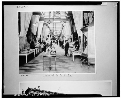 Historic interior view of a department store, featuring displays and shoppers in a bustling atmosphere.