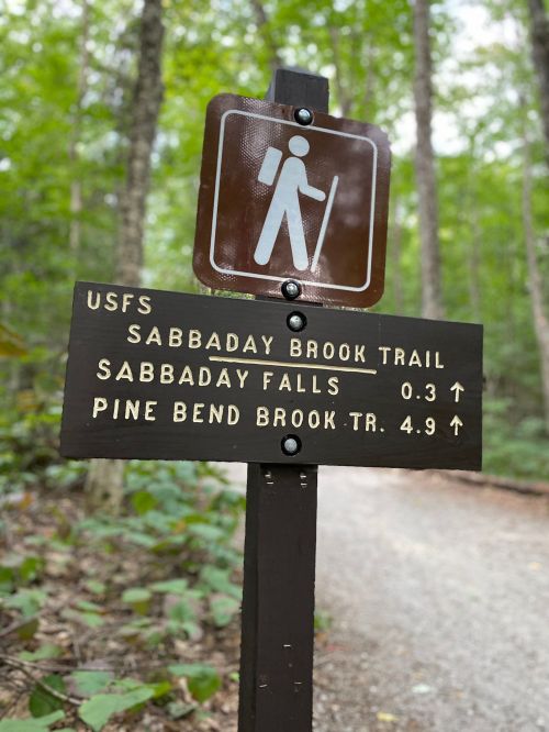 Trail sign for Sabbaday Brook Trail, indicating distances to Sabbaday Falls and Pine Bend Brook Trail.