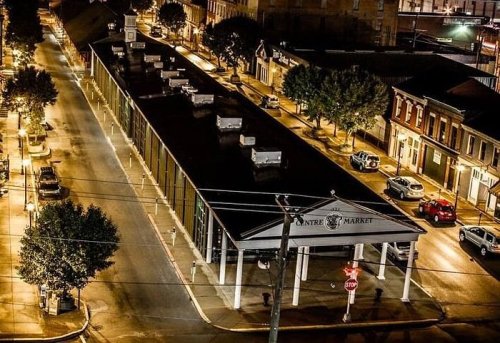 Aerial view of Centre Market at night, showcasing its structure and surrounding streets illuminated by streetlights.