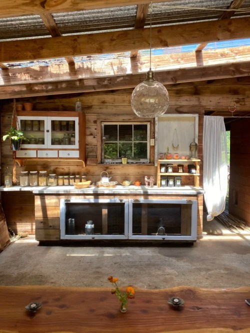 Cozy rustic kitchen with wooden cabinets, a marble countertop, and natural light streaming through a skylight.