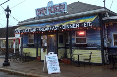 Colorful exterior of Crazy Burger restaurant with outdoor seating, open sign, and menu board in front.