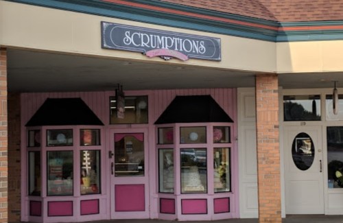 A storefront with a pink facade and the sign "SCRUMPTIONS" above the entrance.