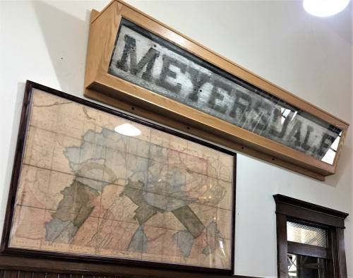 A vintage map displayed on a wall beneath a wooden sign that reads "MEYERJALE."