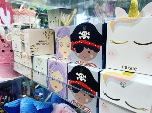 Colorful bath products displayed on a shelf, featuring whimsical designs like pirates and unicorns.