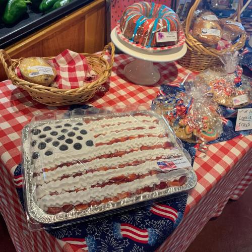 A festive table with a flag-themed cake, cookies, and pastries, all decorated for a patriotic celebration.
