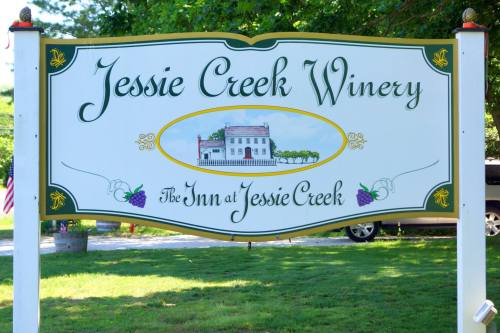 Sign for Jessie Creek Winery featuring a painted illustration of the winery and the text "The Inn at Jessie Creek."
