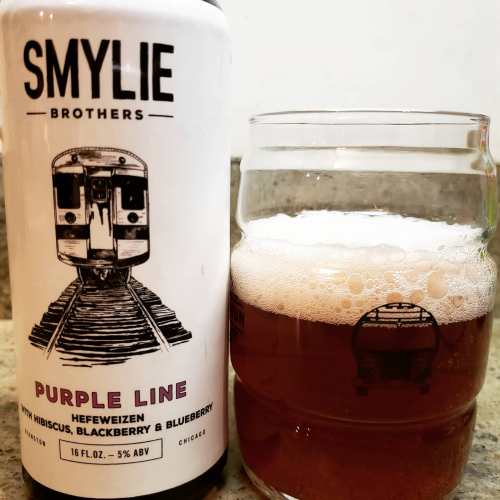 A can of Smylie Brothers Purple Line beer next to a glass filled with the amber beverage, featuring a train illustration.