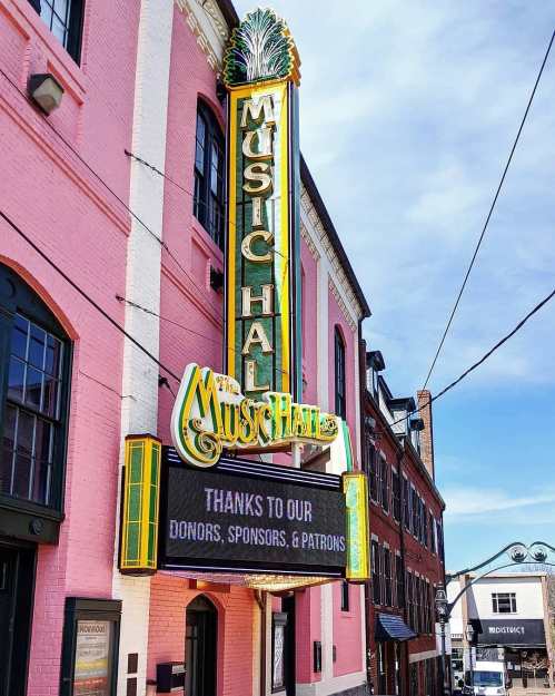 A colorful marquee of the Music Hall building, thanking donors, sponsors, and patrons against a clear blue sky.