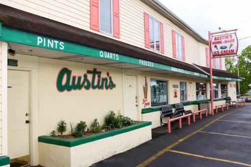 A colorful ice cream shop with a sign reading "Austin's Home-Made Ice Cream" and outdoor seating.