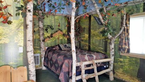 Cozy bedroom with tree-like decor, forest-themed wallpaper, and a quilted bedspread, creating a nature-inspired atmosphere.