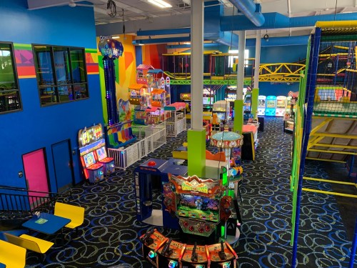 A colorful indoor amusement center with arcade games, climbing structures, and vibrant decor.