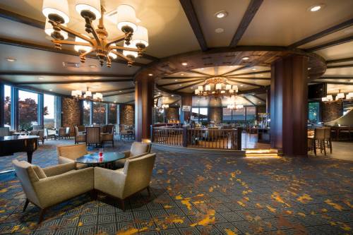 A spacious, modern restaurant interior with elegant lighting, cozy seating, and large windows showcasing a scenic view.